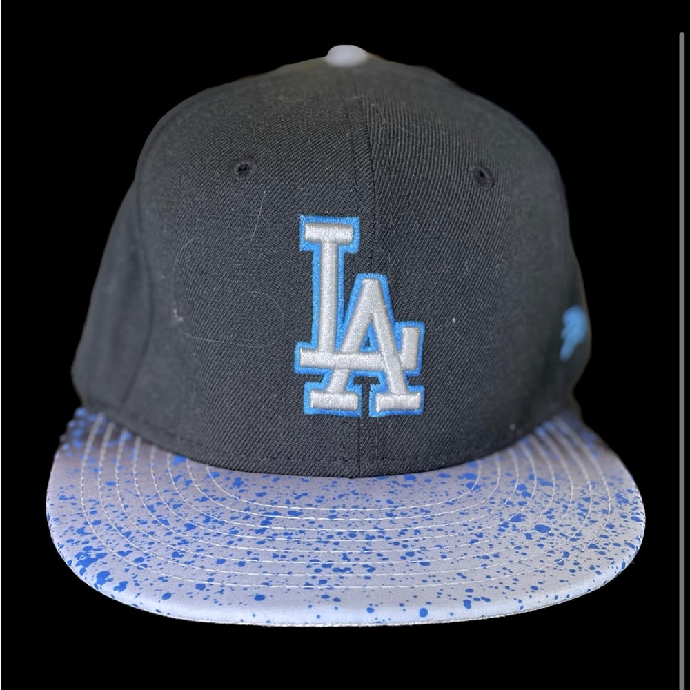 Fitted LA baseball cap with spray paint design on lid.